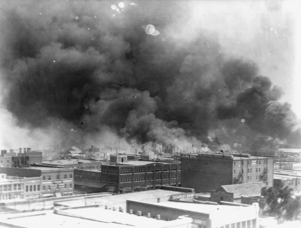 In this 1921 image provided by the Library of Congress, smoke billows over Tulsa, Okla. For decades, when it was discussed at all, the killing of hundreds of people in a prosperous black business district in 1921 was referred to as the Tulsa race riot. Under new standards developed by teachers for approaching the topic, students are encouraged to consider the differences between labeling it a “massacre” instead of a “riot,” as it is still commemorated in state laws. (Alvin C. Krupnick Co./Library of Congress via AP)