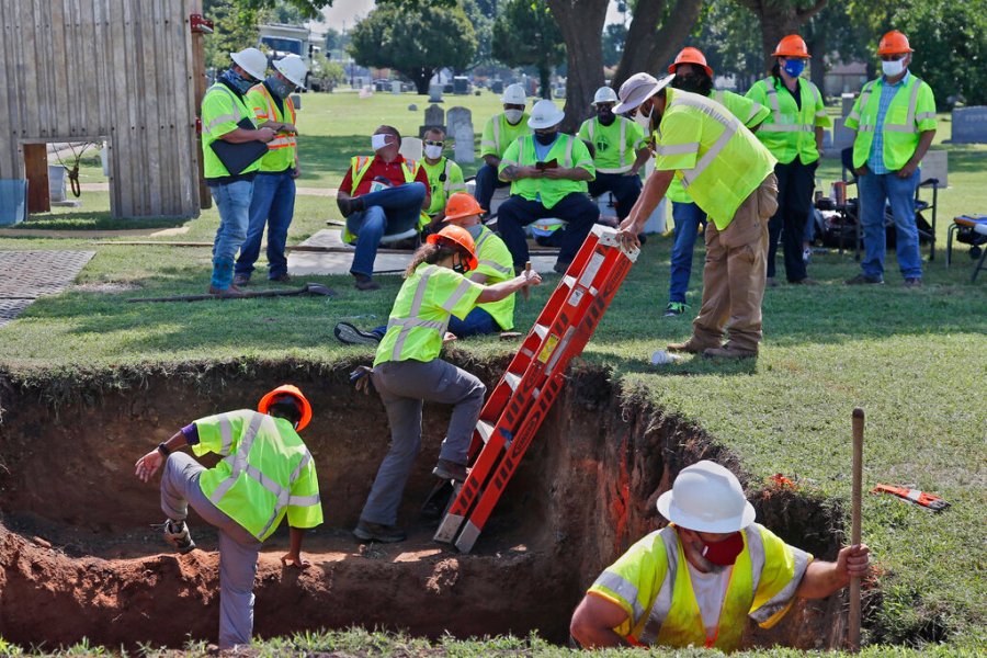 In this July 14, 2020, file photo, workers climb out of the excavation site as work continues on a potential unmarked mass grave from the 1921 Tulsa Race Massacre, at Oaklawn Cemetery in Tulsa, Okla. (AP Photo/Sue Ogrocki File)