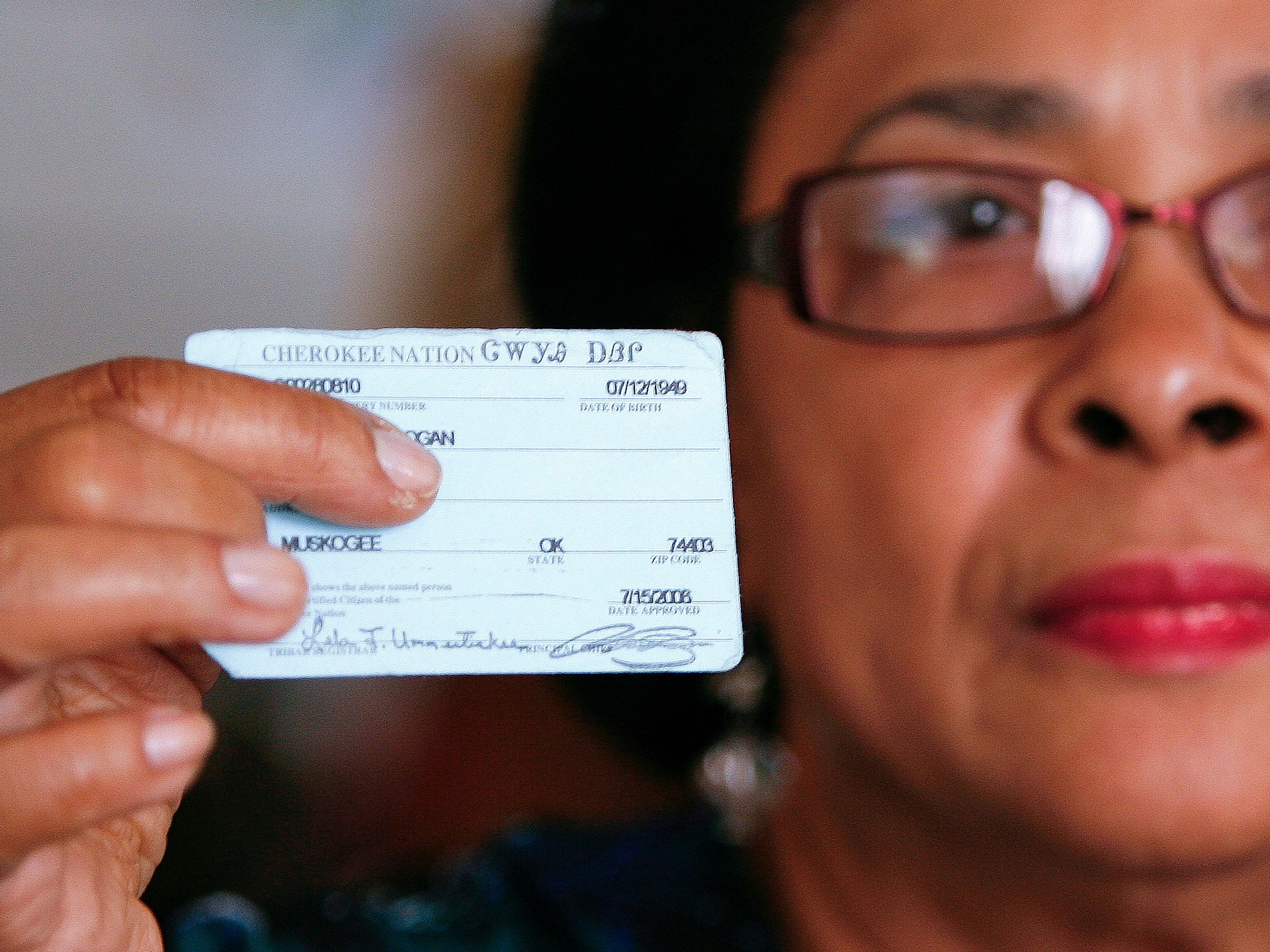 In this Oct. 6, 2011 photo, Rena Logan, a member of a Cherokee Freedmen family, shows her identification card as a member of the Cherokee tribe at her home in Muskogee, Okla. Thousands of people whose ancestors were enslaved by the Cherokee Indians in the 1800s are fighting to keep their status as members of the tribe. Loss of citizenship could also mean losing valuable tribal benefits such as medical care, housing assistance and grocery stipends. Logan, a retired cook who keeps her ancestors Freedmen Roll number of 3918 close to her heart every day, gets treatment at tribal clinics for her arthritis, hypertension, osteoarthritis and a dislocated back disc. We are black, and we were slaves, and they want to keep us that way, Logan said. It really hurts the heart. What did we do to be discriminated against? (AP Photo/Dave Crenshaw)