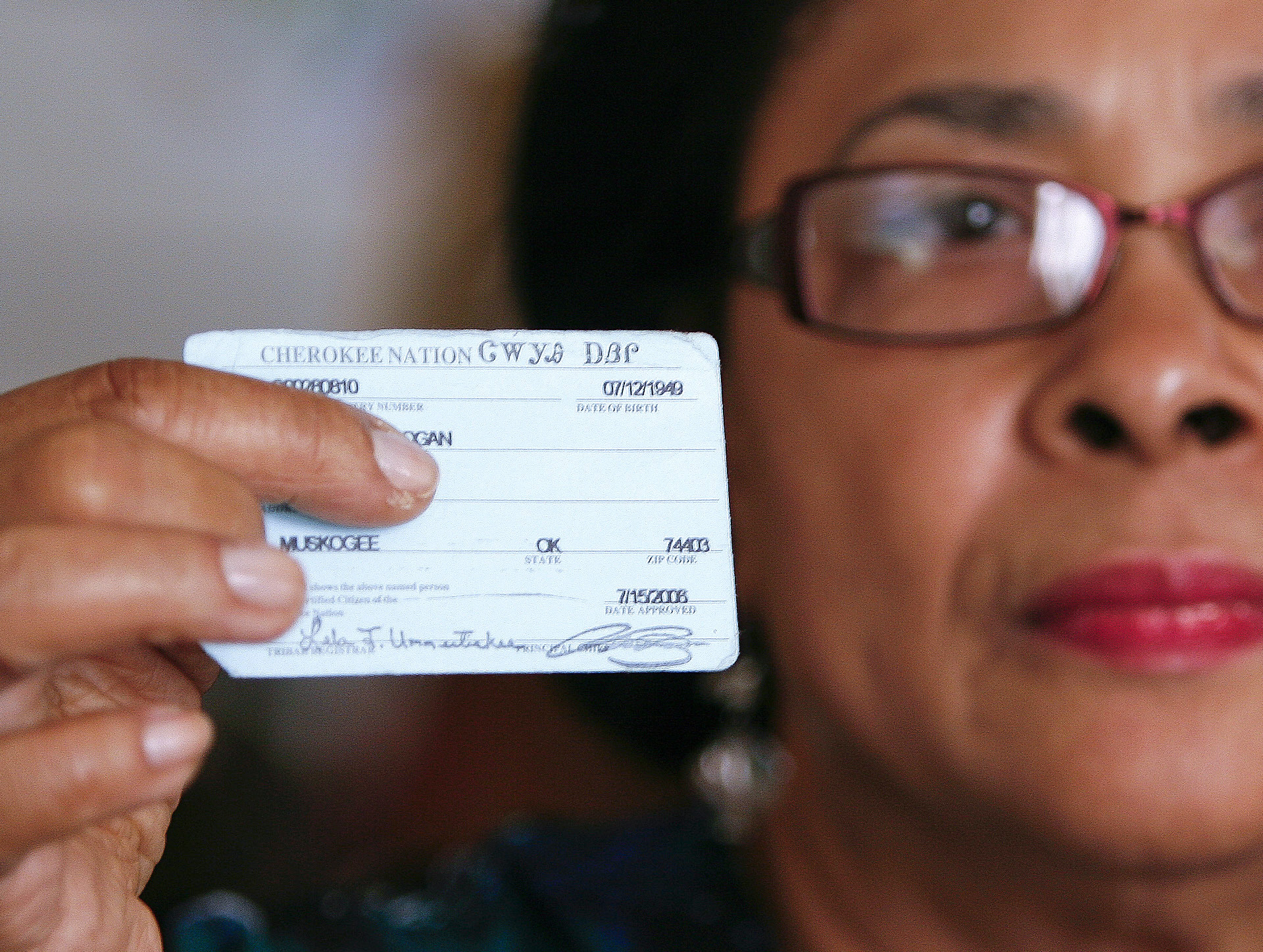 In this Oct. 6, 2011 photo, Rena Logan, a member of a Cherokee Freedmen family, shows her identification card as a member of the Cherokee tribe at her home in Muskogee, Okla. Thousands of people whose ancestors were enslaved by the Cherokee Indians in the 1800s are fighting to keep their status as members of the tribe. Loss of citizenship could also mean losing valuable tribal benefits such as medical care, housing assistance and grocery stipends. Logan, a retired cook who keeps her ancestors Freedmen Roll number of 3918 close to her heart every day, gets treatment at tribal clinics for her arthritis, hypertension, osteoarthritis and a dislocated back disc. We are black, and we were slaves, and they want to keep us that way, Logan said. It really hurts the heart. What did we do to be discriminated against? (AP Photo/Dave Crenshaw)