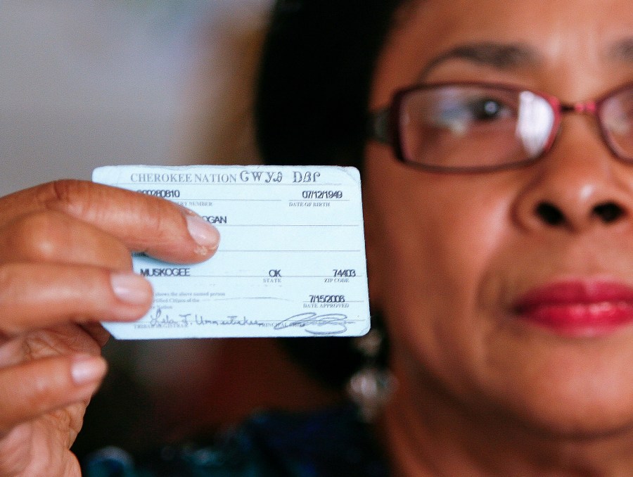 In this Oct. 6, 2011 photo, Rena Logan, a member of a Cherokee Freedmen family, shows her identification card as a member of the Cherokee tribe at her home in Muskogee, Okla. Thousands of people whose ancestors were enslaved by the Cherokee Indians in the 1800s are fighting to keep their status as members of the tribe. Loss of citizenship could also mean losing valuable tribal benefits such as medical care, housing assistance and grocery stipends. Logan, a retired cook who keeps her ancestors Freedmen Roll number of 3918 close to her heart every day, gets treatment at tribal clinics for her arthritis, hypertension, osteoarthritis and a dislocated back disc. We are black, and we were slaves, and they want to keep us that way, Logan said. It really hurts the heart. What did we do to be discriminated against? (AP Photo/Dave Crenshaw)