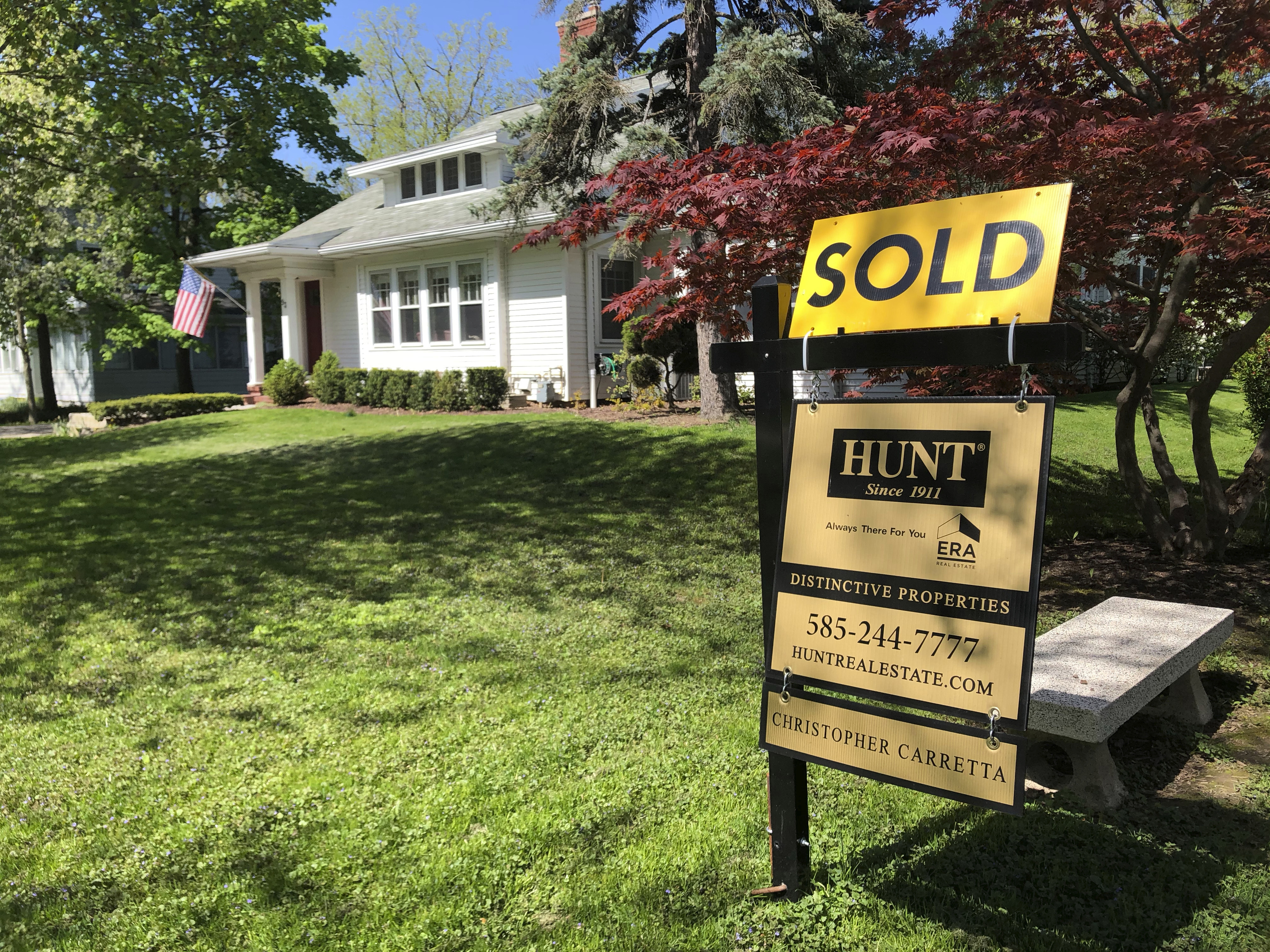 a sold sign sits in front of a house in Brighton, N.Y.