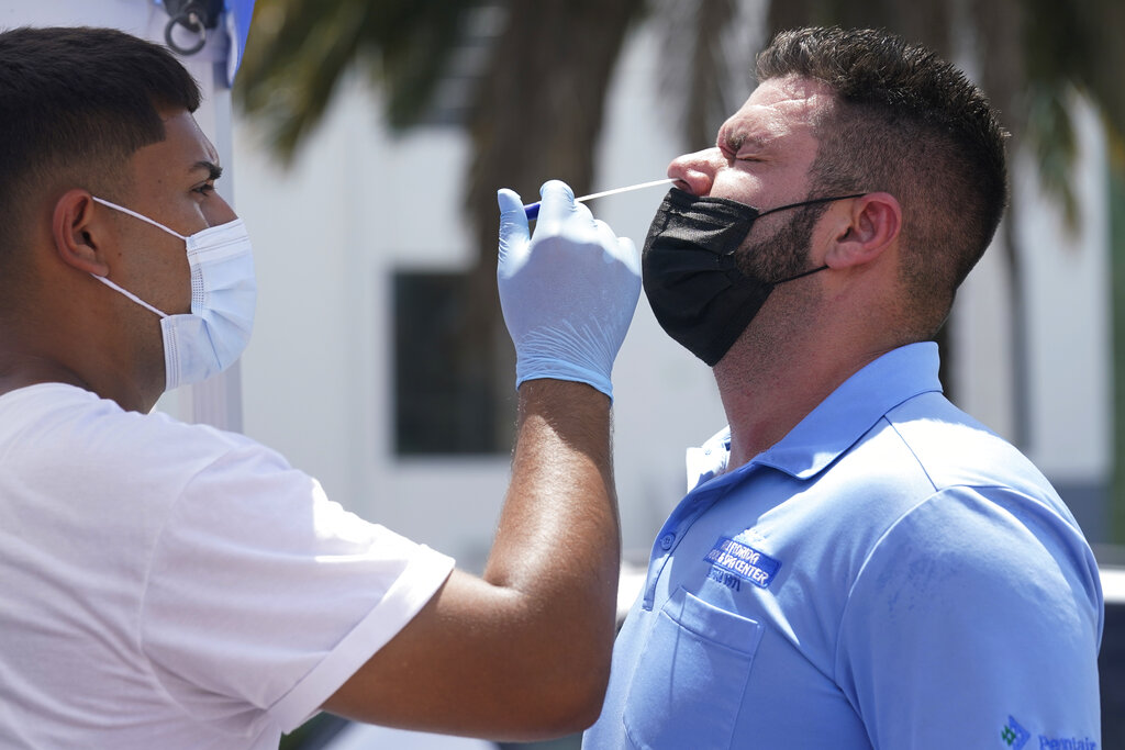 MS technician Emmanuel Orrego, left, administers the COVID-19 PCR test to Yosdany Lugo, Monday, July 26, 2021, in Miami. Florida accounted for a fifth of the nation's new infections last week, more than any other state, according to the CDC. (AP Photo/Marta Lavandier)