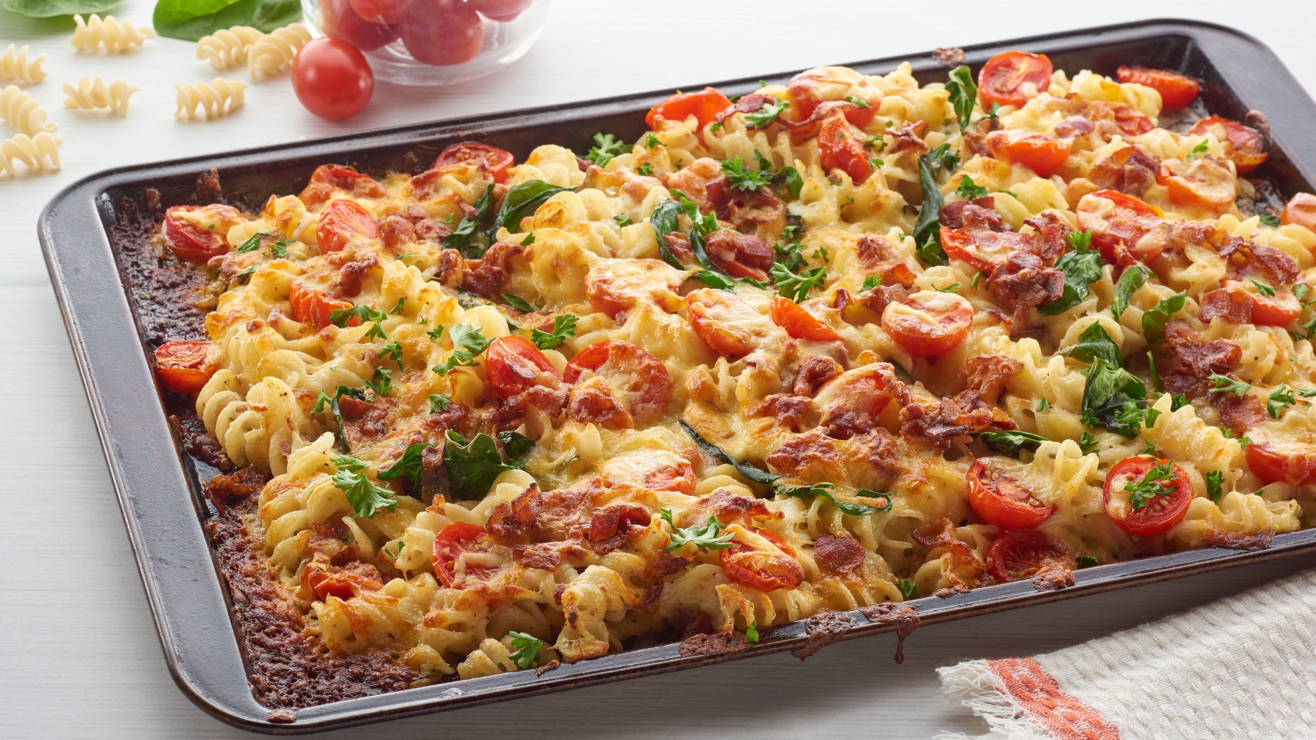 Sheet pan pasta with spinach, tomato, and bacon