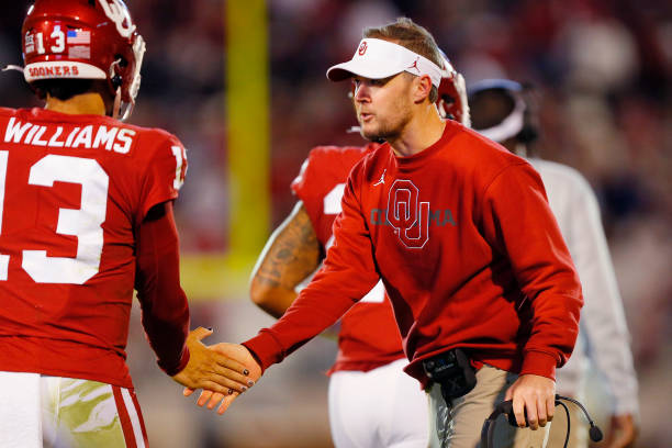 NORMAN, OK - OCTOBER 16: Head coach Lincoln Riley congratulates quarterback Caleb Williams #13 of the Oklahoma Sooners after a touchdown against the Texas Christian University Horned Frogs in the fourth quarter at Gaylord Family Oklahoma Memorial Stadium on October 16, 2021 in Norman, Oklahoma. Oklahoma won 52-31. (Photo by Brian Bahr/Getty Images)