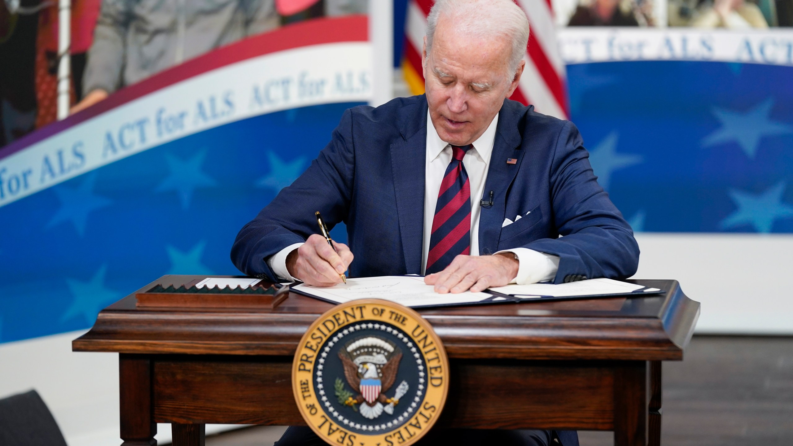 President Joe Biden signs the "Accelerating Access to Critical Therapies for ALS Act" into law during a ceremony in the South Court Auditorium on the White House campus in Washington, Thursday, Dec. 23, 2021. (AP Photo/Patrick Semansky)