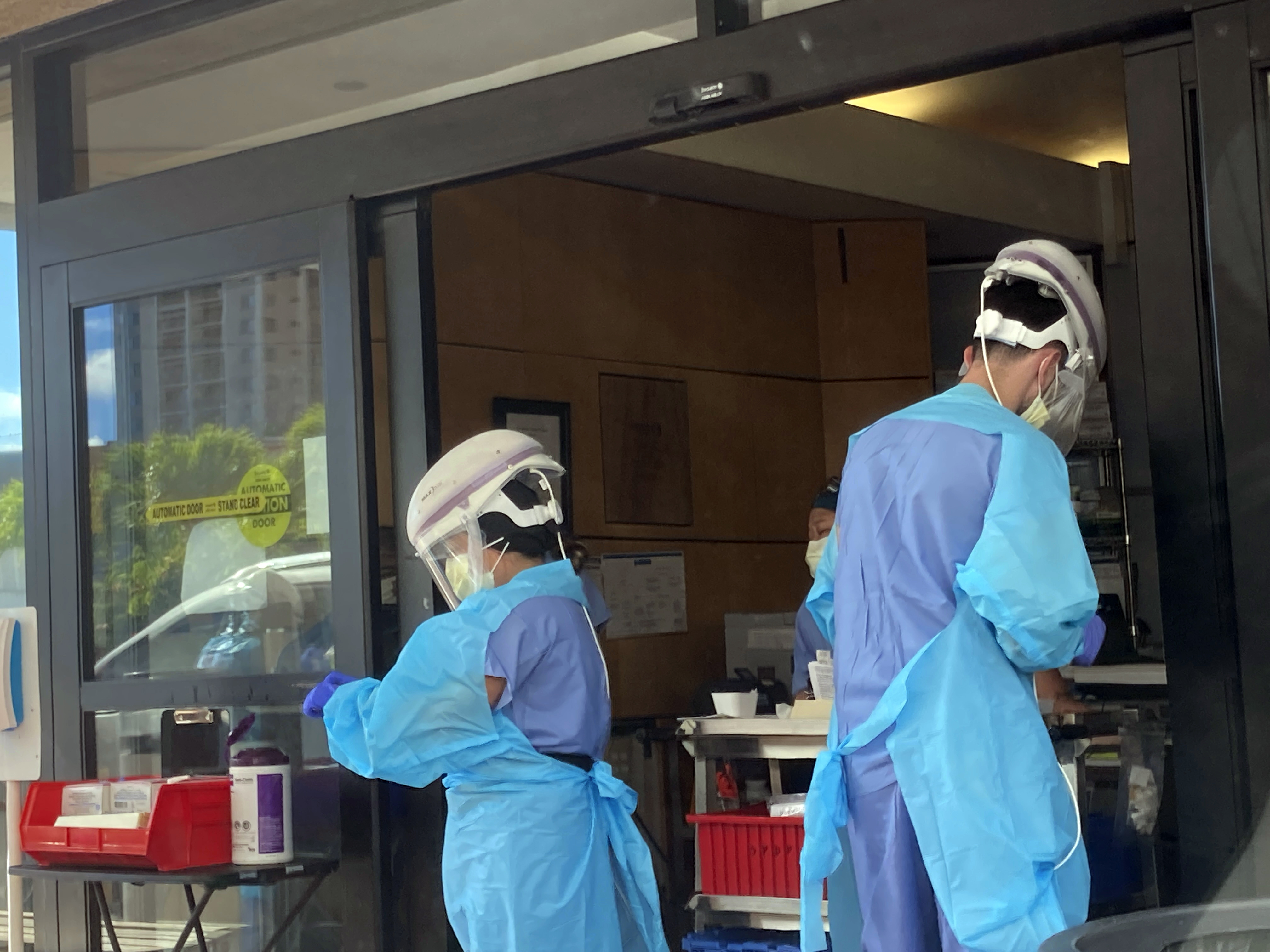 FILE - Hospital workers process COVID-19 tests at a hospital in Aiea, Hawaii, Wednesday, Sept. 15, 2021. The Centers for Disease Control and Prevention posted revised guidelines on Thursday, Dec. 23, 2021, that are loosening rules that call on health care workers to stay out of work for 10 days if they test positive for COVID-19. Those workers will be allowed to come back to work after seven days if they test negative and don’t have symptoms. (AP Photo/Caleb Jones, File)