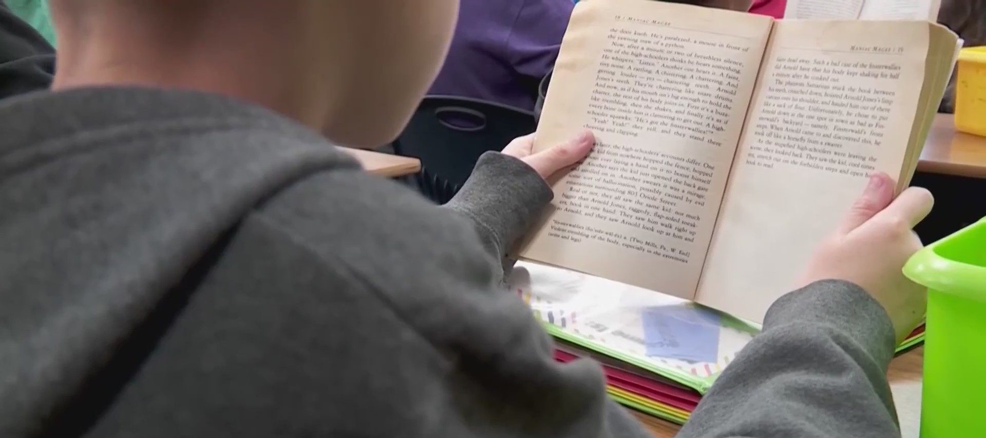 Student reads book in classroom