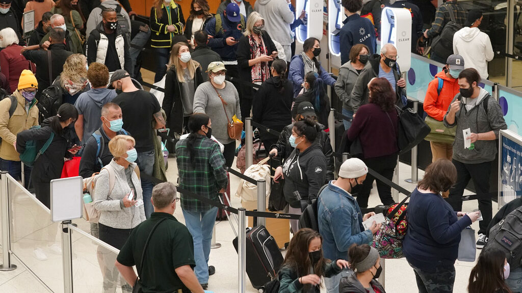 Travelers are seen waiting to pass through a TSA security checkpoint on Dec. 10, 2021, at the Seattle-Tacoma International Airport in Seattle.